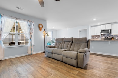 Living area featuring baseboards, visible vents, l