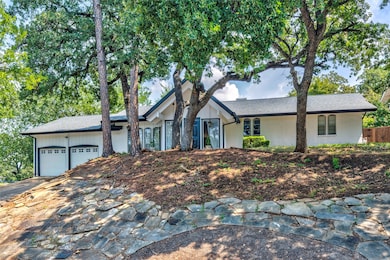 Single story home featuring an attached garage, brick siding, driveway, and a shingled roof