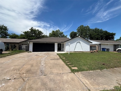 Single story home featuring a garage, brick siding