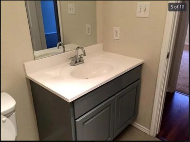 Half bathroom featuring baseboards, vanity, and t