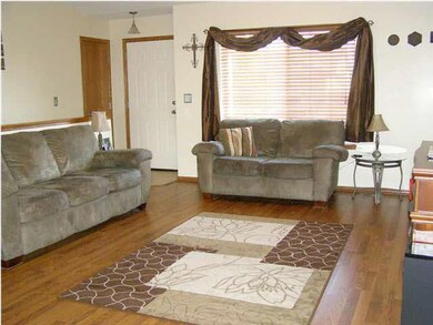 Living room has laminate wood floors and wood blin