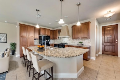 Virtually Staged- Kitchen featuring tasteful backsplash, a kitchen island with sink, stainless steel gas range, black fridge with ice dispenser, and custom range hood
