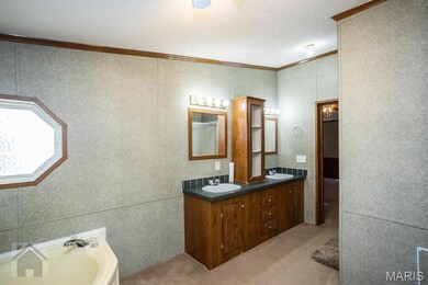 Bathroom with a textured ceiling, double vanity, molding trim, separate shower, and a corner tub to relax in