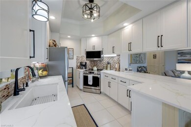 Kitchen with a tray ceiling, white cabinetry, deco