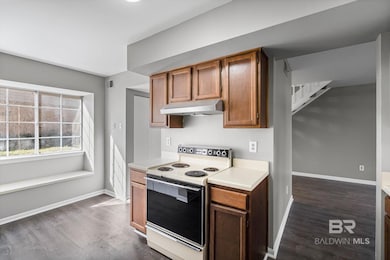 Kitchen featuring range with electric cooktop, light countertops, dark wood-style flooring, and under cabinet range hood