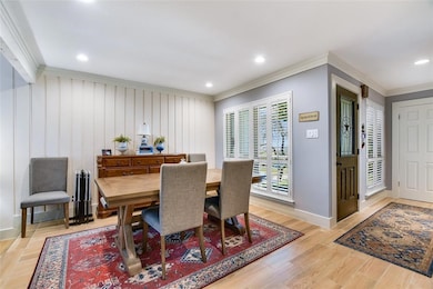 Dining space with crown molding, baseboards, ligh