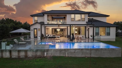 Back of property at dusk featuring an outdoor liv
