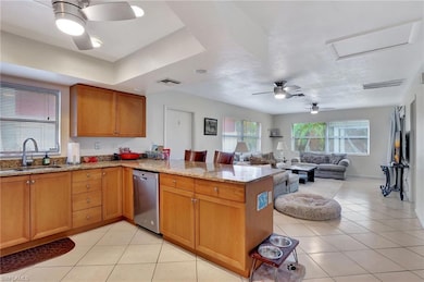 Kitchen with sink, light stone counters, light til