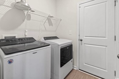 Laundry area with light wood-type flooring and ind