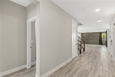 Corridor featuring light wood-style floors, recess