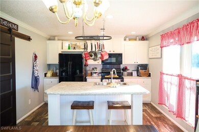 Kitchen with sink, black appliances, a center isla