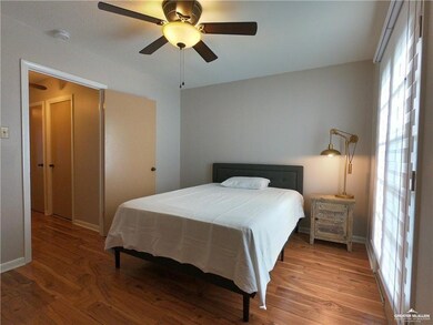 Bedroom featuring wood finished floors, baseboards, and a ceiling fan