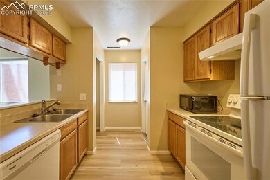 Kitchen with white appliances, a sink, and brown c