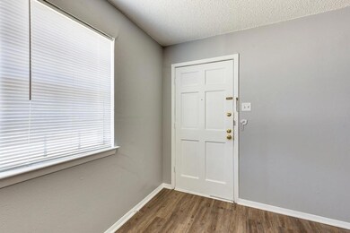 Doorway featuring a textured ceiling and dark hardwood / wood-style floors