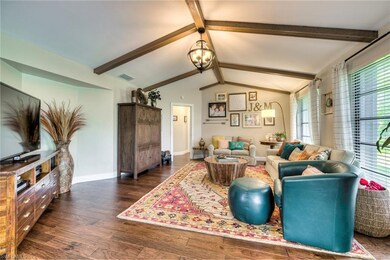 Family room with wood floors, exposed beams and custom light fixture