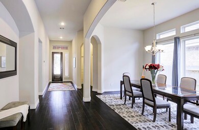 What a view from inside the designer glass inset door ... Beautiful wood floors! Arched entryways, rounded sheet rock corners! Windows & windows & windows! Providing lots of natural light! Wide entryway makes ease of movement and flow.