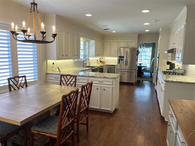 Kitchen with a sink, white cabinetry, hanging ligh