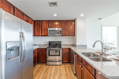 Kitchen featuring light stone countertops, light w