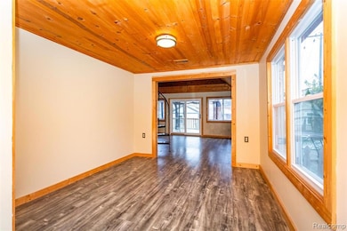 Unfurnished room featuring dark wood-style floors and wood ceiling