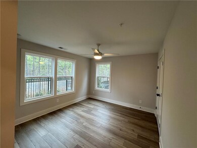 Empty room with dark wood-type flooring, baseboard