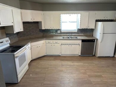 Kitchen with white cabinets, white appliances, sin
