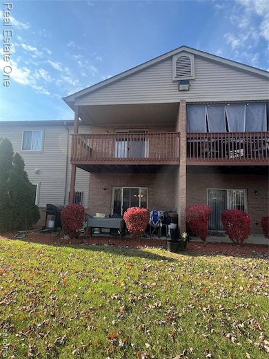 Rear view of property with brick siding, a patio area, and a yard