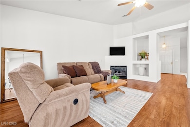 Living room with ceiling fan, built in shelves, li