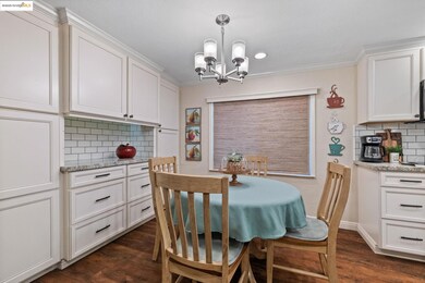 Dining area featuring dark wood-style floors, ornamental molding, and a chandelier