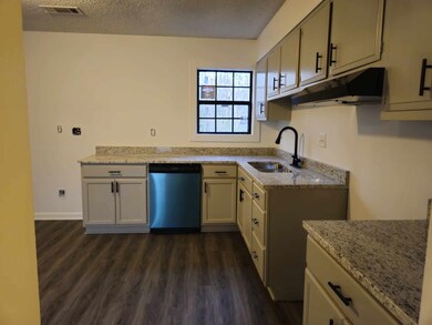 Kitchen featuring dishwasher, sink, light stone co