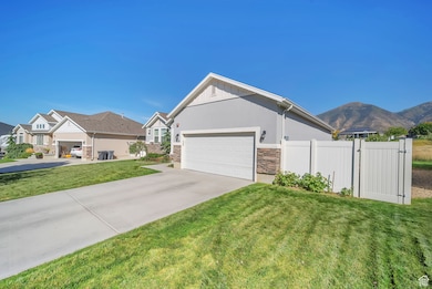 View of home's exterior featuring concrete driveway, stucco siding, stone siding, a garage, and a mountain view