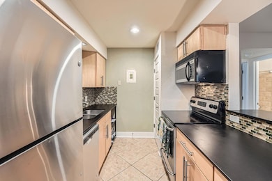 Kitchen with dark countertops, light brown cabine
