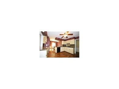 Kitchen's wide plank wood flooring flows into Grea