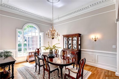 Dining room is stunning with wainscoting and detailed crowned molding.
