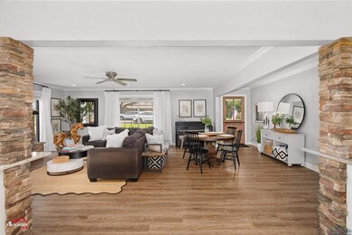 Living area with ornamental molding, wood finished floors, decorative columns, ceiling fan, and recessed lighting