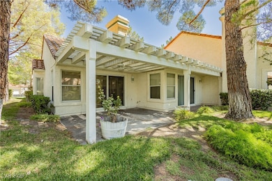 Rear view of property with stucco siding, a pergol