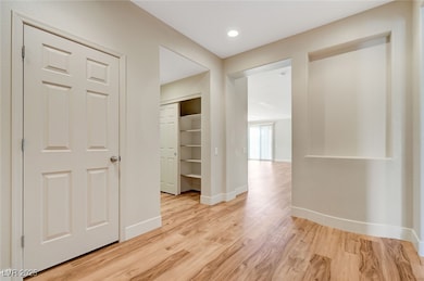 Corridor featuring light wood-type flooring and ba