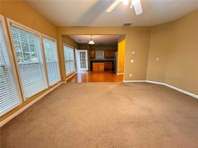 Unfurnished living room featuring light colored carpet and a ceiling fan