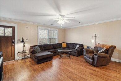 Living room featuring ornamental molding, light wo