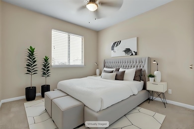 Bedroom with light colored carpet and baseboards