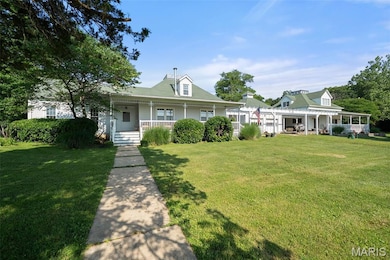 Farmhouse inspired home with covered porch and a front lawn
