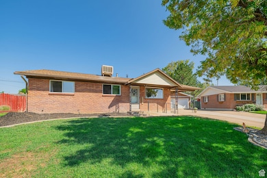 Single story home featuring a front yard, brick siding, and driveway