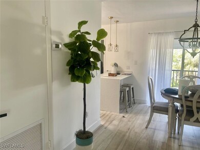 Dining room with light wood-style flooring, a notable chandelier, and baseboards