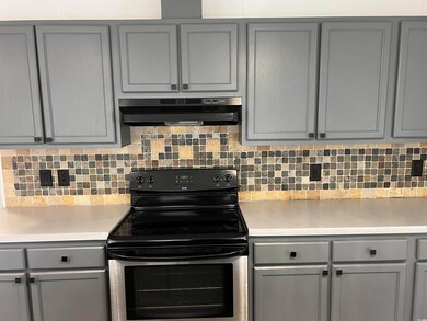 Kitchen featuring gray cabinets, electric range, a