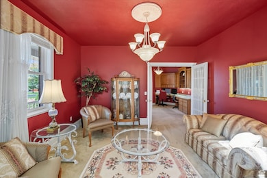 Living area featuring an office area, light carpet, and a chandelier