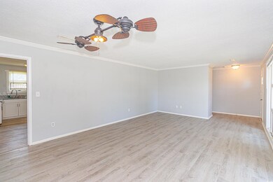 Empty room featuring sink, crown molding, light wo