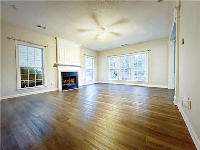 Unfurnished living room with visible vents, a text