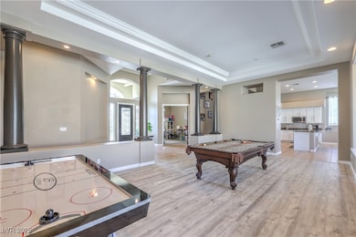 Playroom with decorative columns, a tray ceiling, recessed lighting, billiards table, and light wood-type flooring