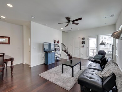 Living area with ceiling fan, dark wood-style flo