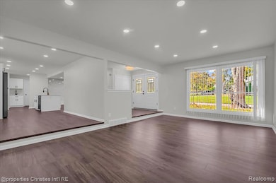 Unfurnished living room featuring dark wood-style floors and recessed lighting