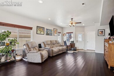 Living room with visible vents, dark wood-style fl